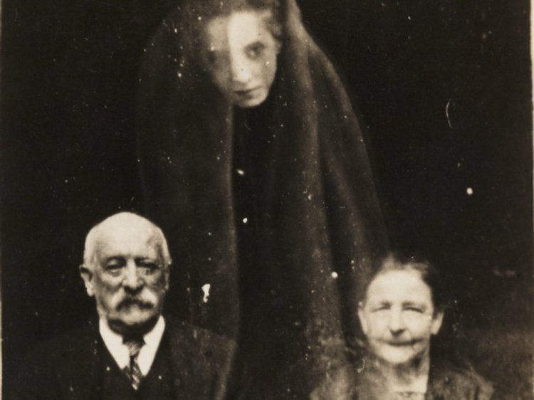 6. Уильям Хоуп, первопроходец в спиритической фотографии, сделал этот снимок пожилой пары и предполагаемого призрака женщины в 1920 году.