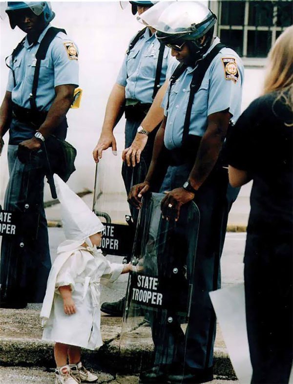 20. Ребенок дотрагивается до своего отражения в полицейском щите на демонстрации в Джорджии, США, 1992 год