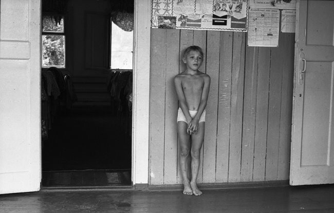 В «тихий час» наказаный за проступок мальчик стоит на веранде спального корпуса. Спортивный лагерь «Металлург», Кузбасс, 9 августа 1979 года.  