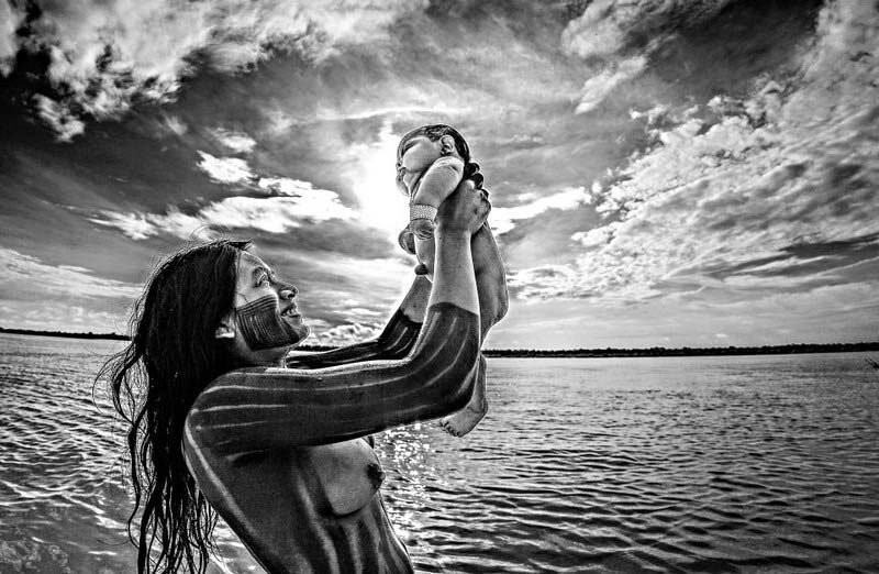 Индианка из племени Kayapó купает своего ребенка в реке Шингу, штат Мату-Гросу