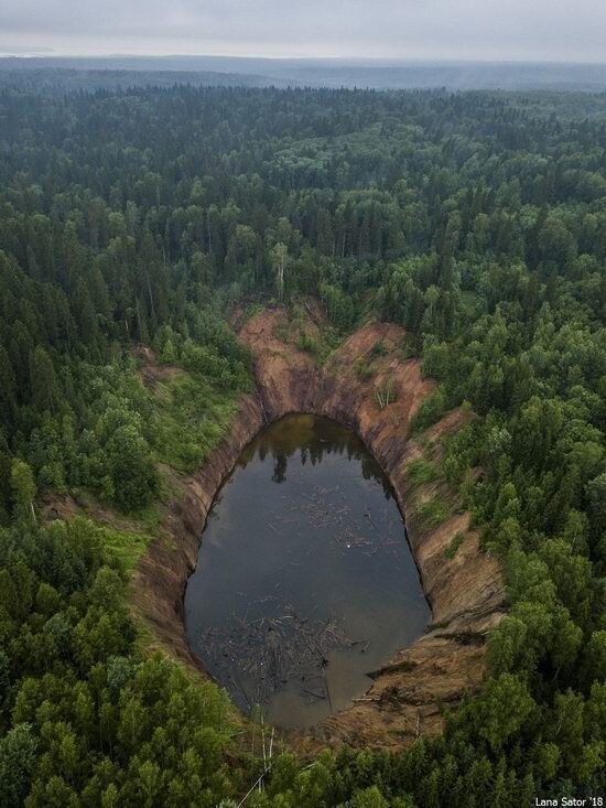 Воронка расположена в глухом лесу