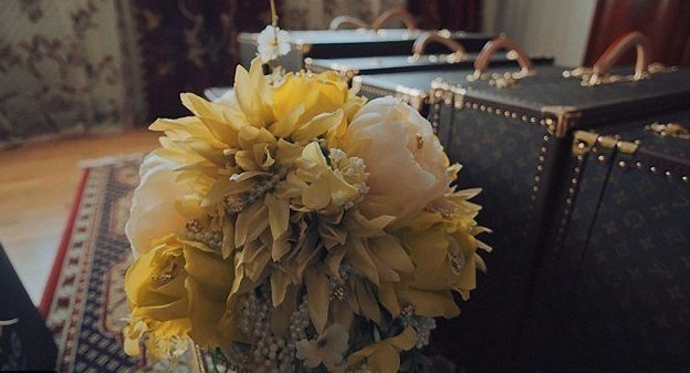 Букет невесты на фоне чемоданов от Louis Vuitton