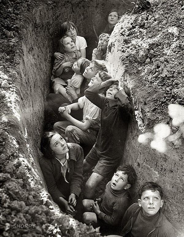 Испуганные дети в траншее во время немецкой бомбардировки, примерно 1940-41 годы