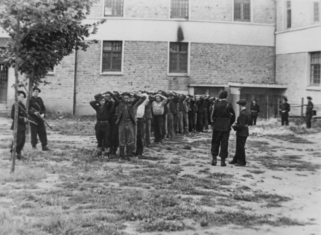 Французская милиция охраняет арестованных, подозреваемых в причастности к партизанам. Французское государство. 1944 год.