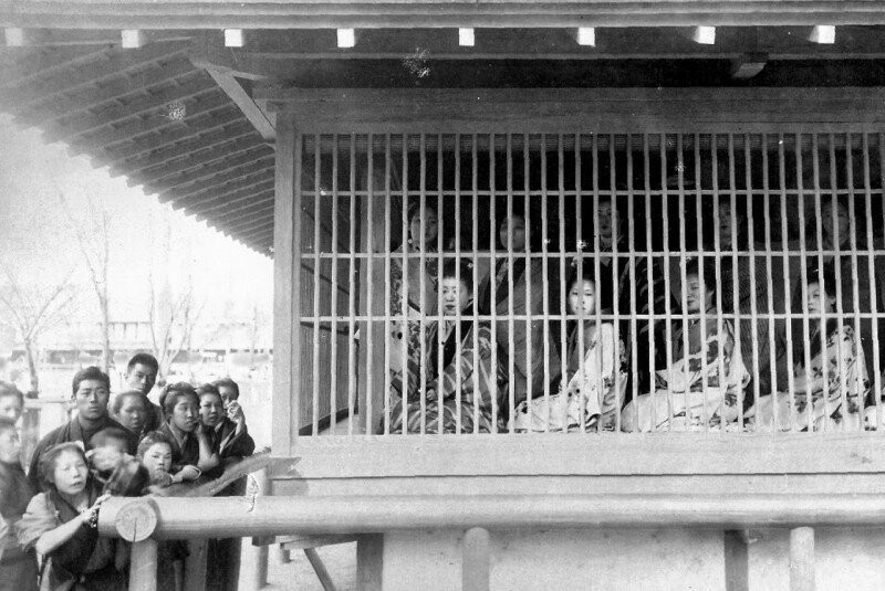 Выставленные на продажу проститутки за решеткой в борделе. Япония. 1890 год.