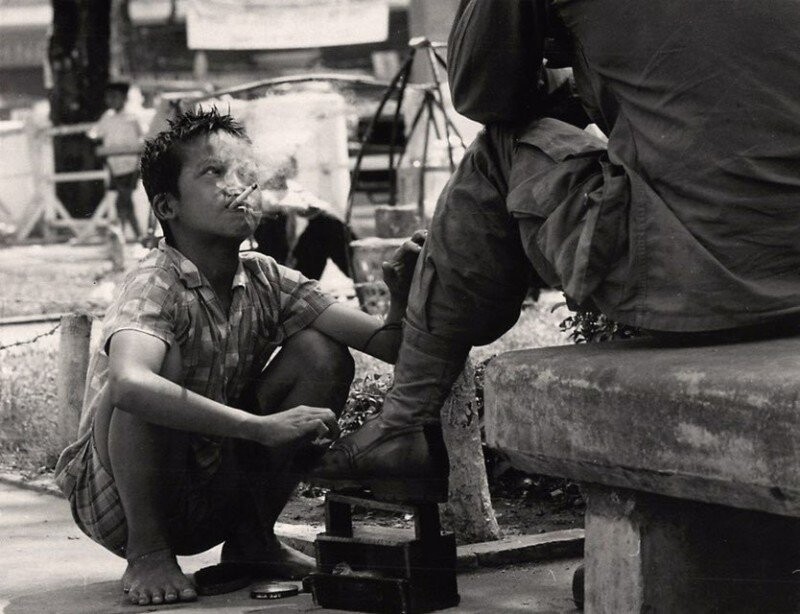 Вьетнамский мальчик чистит ботинки американскому солдату. Вьетнам, Сайгон. 1968 год.