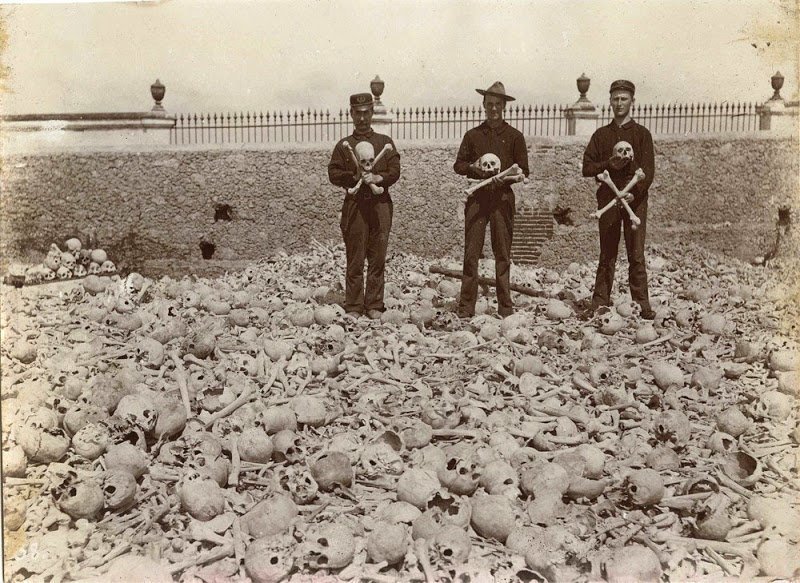 Американские солдаты стоят на вершине почти двухсот тысяч скелетов на кладбище Колон, Гавана, Куба. Около 1899 года.
