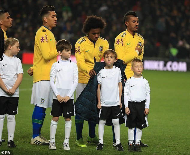 Это не первый случай, когда футболисты заботятся о детях - на фото бразильский футболист Виллиан также укрывает мальчика своей курткой.