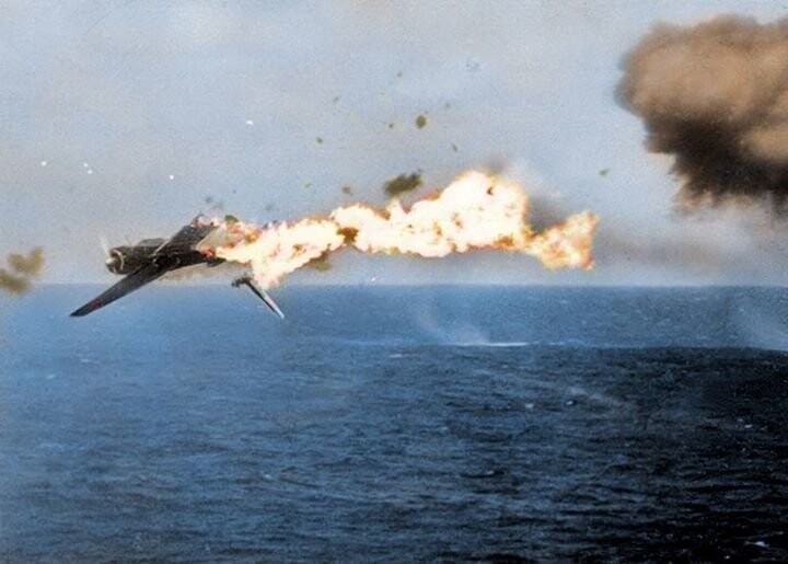 Японский палубный торпедоносец B5N разрушается в результате попадания 5-дюймового снаряда с борта авианосца «Йорктаун». 25 октября 1944 г. (в оригинале фото чёрно-белое)