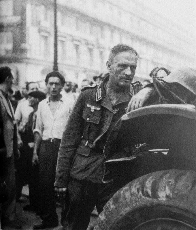 Сдавшийся в плен фельдфебель вермахта в окружении жителей освобожденного Парижа. Август 1944 г.