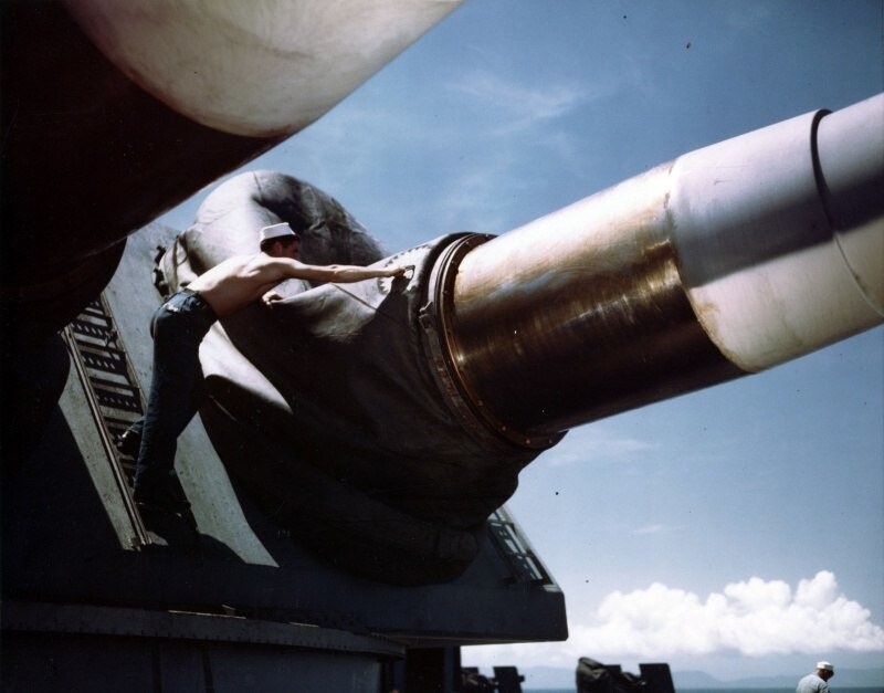 Матрос из состава экипажа американского линкора «Миссури» поправляет кожух на главном калибре. Август 1944 г.