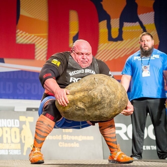 Болгарин Димитар Саватинов пытается поднять огромный камень (186 кг) на соревновании силачей