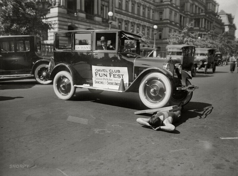 Силач демонстрирует свое умение выдерживать вес автомобиля на фестивале Fun Fest, Вашингтон, 1923 год.