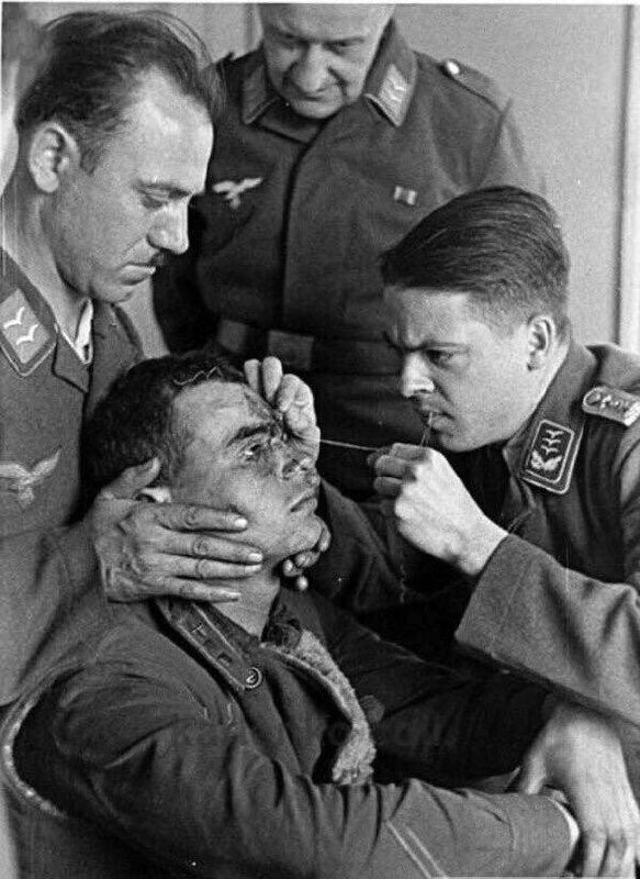 ​​Немецкие летчики зашивают рану сбитому советскому летчику, 1941 год.