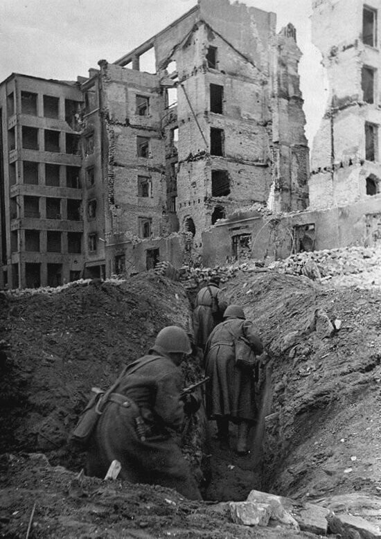 Бойцы 13-й Гвардейской дивизии передвигаются по вырытым между зданиями переходам в Сталинграде. Осень 1942 г.