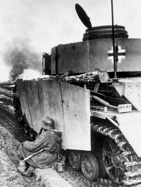 Немецкий солдат укрывается за бронёй танка Pz.IVJ из 5-го танкового батальона 5-го танкового полка СС дивизии "Викинг". Венгрия, 1945 г.