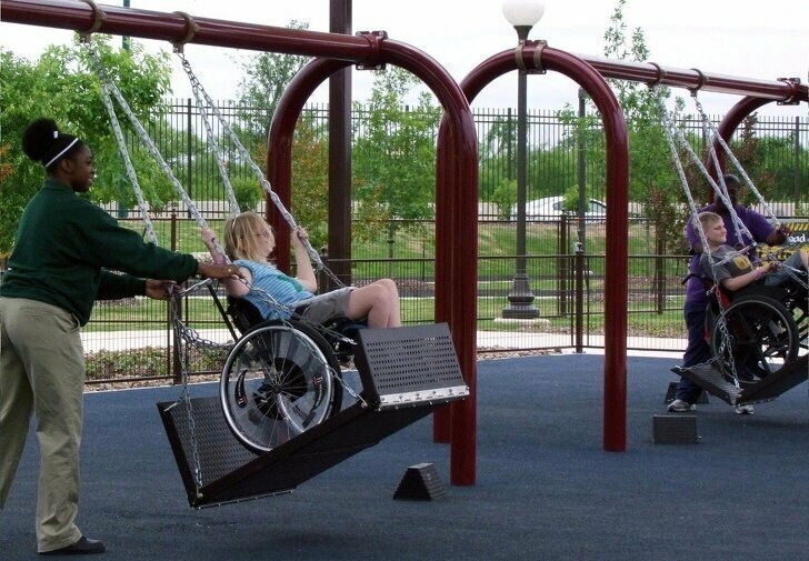 Специальные качели для детей в инвалидных колясках на детской площадке