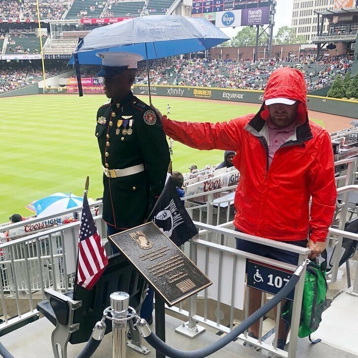 Этот парень держит зонтик над солдатом, который стоит у мемориальной доски, посвященной погибшим во времена Первой мировой войны солдатам 