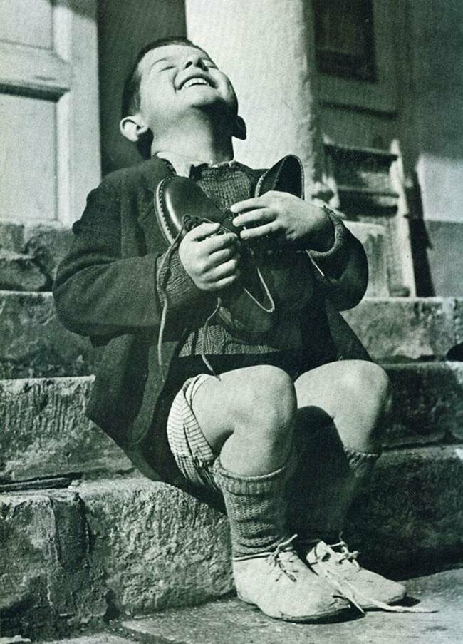 Австрийский мальчик невероятно взволнован, он получил свою первую пару новых туфель за последние годы (1946)