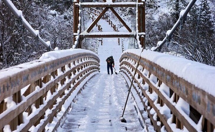 Доброволец убирает снег с моста в Спокане, США