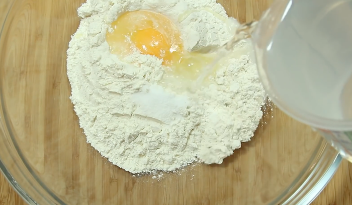 Тесто: В муку добавляем соль, яйцо и наливаем воду.