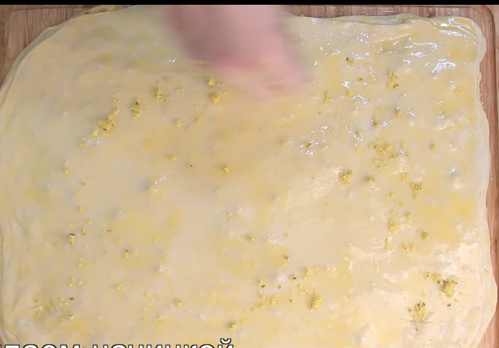 Делим тесто на 8-9 частей Раскатываем тонкий пласт менее 1мм. Смазываем растопленным маслом. Посыпаем начинкой.