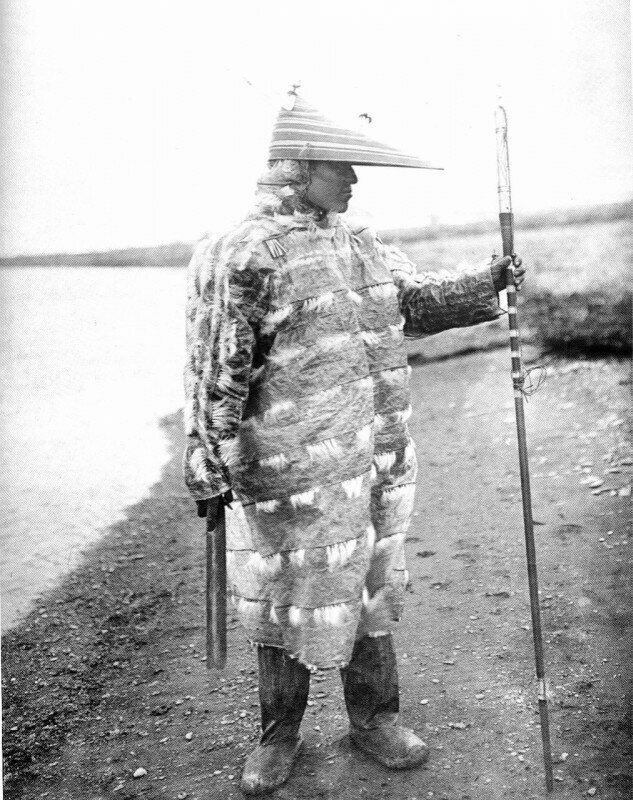 Алеут-охотник в традиционной непромокаемой одежде из кишок морского льва, Аляска, 1905 год.