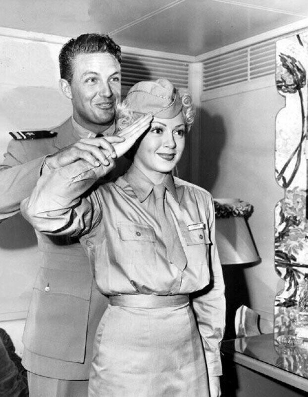 Лейтенант военно-морского флота Роберт Стак учит Лану Тернер как правильно отдавать честь. Октябрь 1944 года