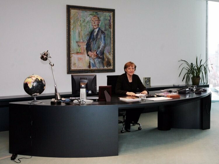 Ангела Меркель часто фотографируется рядом с большим черным столом, хотя работает она совсем не за ним