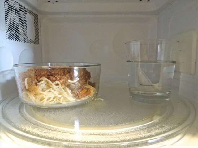 6. Поставьте стакан с водой в микроволновку, когда будете греть блюдо: так еда не пересушится