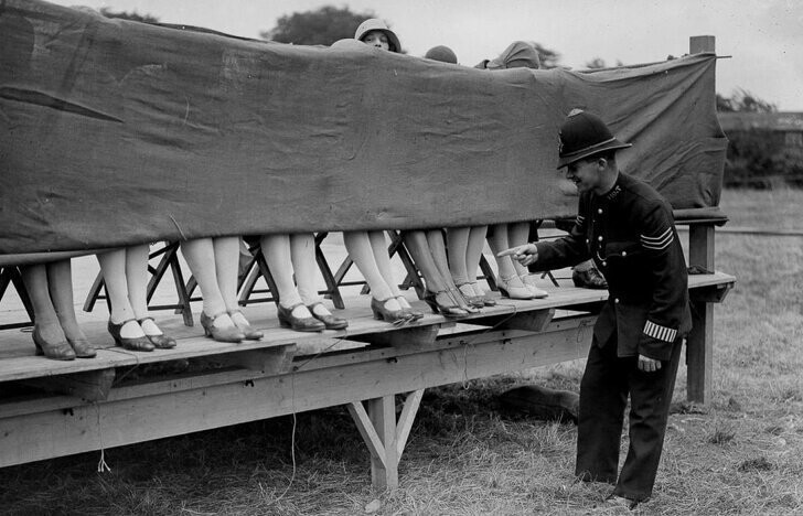 Полицейский выступает в качестве судьи на соревнованиях по красоте женских лодыжек, Лондон, 1930 год