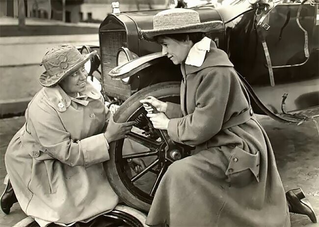 Американские суфражистки Маргарет Уиттемор и Марджери Роуз меняют колесо на машине во время поездки по городам США, 1916 г.