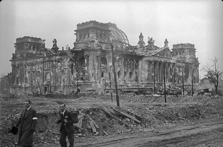Мирные жители проходят возле здания Рейхстага в Берлине после боев, 1945 год