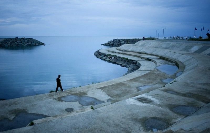 Мужчина прогуливается по берегу. Трабзон, Турция.