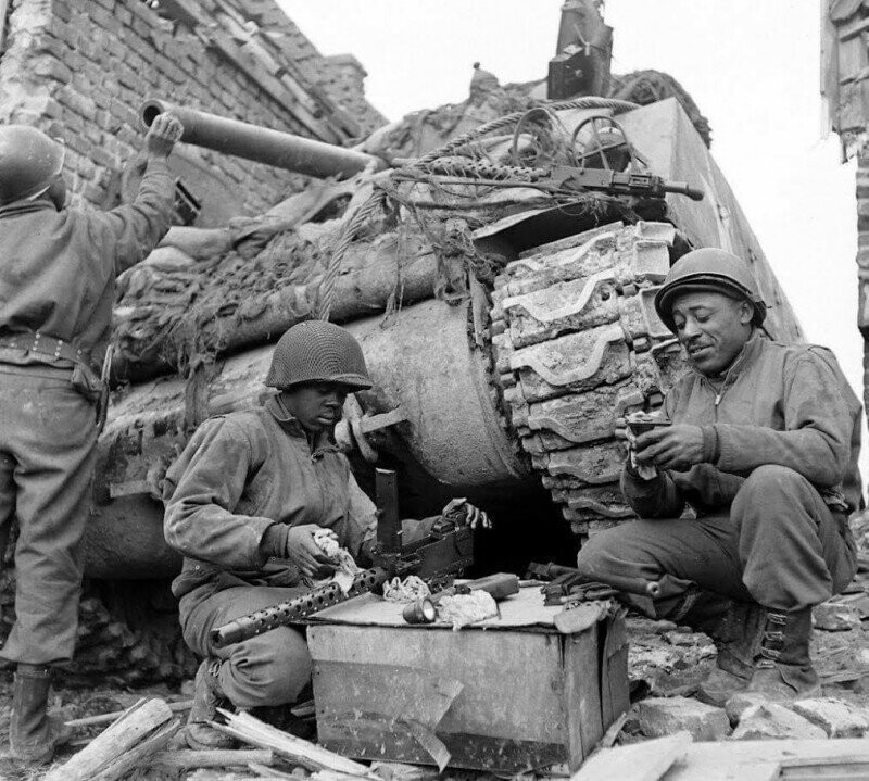 Танкисты американского 761-го танкового батальона во время обслуживания техники в перерыве между боями. Батальон был укомплектован неграми. 1945 год. Германия. 