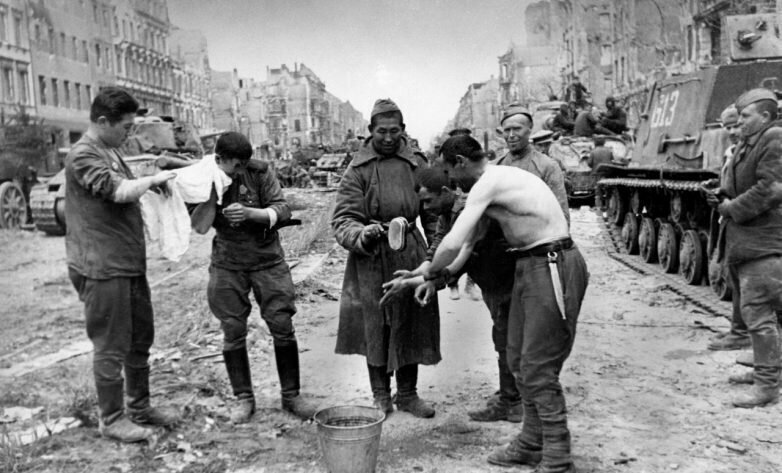 Советские солдаты моются между танками на одной из улиц Берлина. 