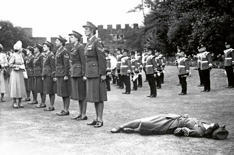 Девушка из почетного женского королевского армейского корпуса потеряла сознание от жары во время встречи с принцессой Елизаветой на выставке Королевского сельскохозяйственного общества в Шрусбери, Англия, 6 июля 1949 года