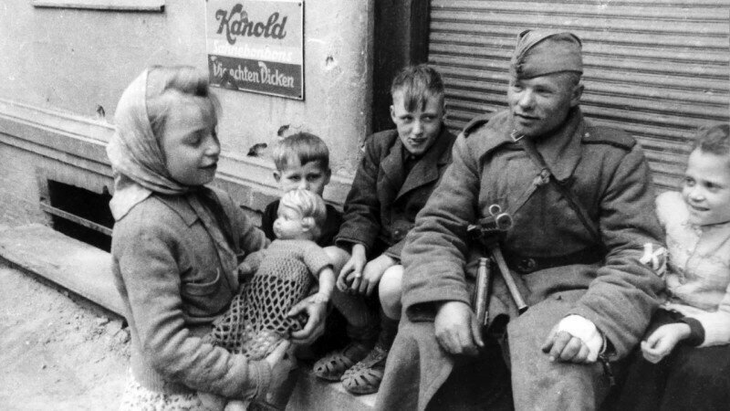 Советский солдат и немецкие дети. Германия, 24 мая 1945 года.