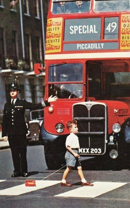 Двухэтажный автобус пропускает мальчика, переходящий дорогу, 1960 год ... и да, у мальчика тоже есть двухэтажный автобус.
