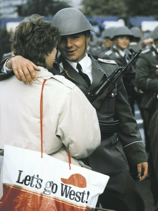 Солдат после парада, посвященного 40-летию ГДР, обнимает жену. Примечательна надпись на пакете. Берлин, 1989