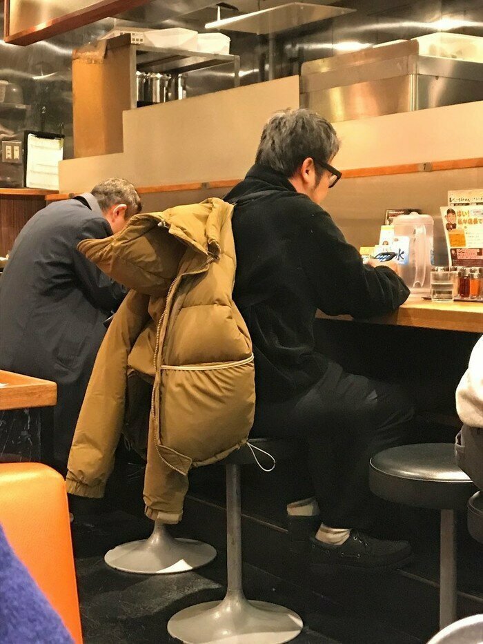 Просто мужик сидит в просто куртке на лямках