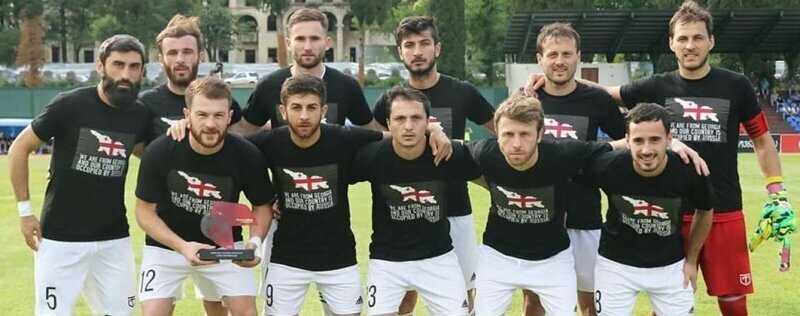Сегодня в стране идет XIX тур чемпионата Грузии по футболу, и футболисты нескольких грузинских клубов вышли на поле в черных майках, с надписями, обвиняющими в оккупации нашу страну. 