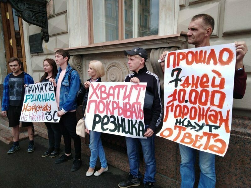 Участники пикета держат в руках лозунги «Хватит покрывать Резника» и «Прошло семь дней, 10 тысяч горожан ждут ответа».