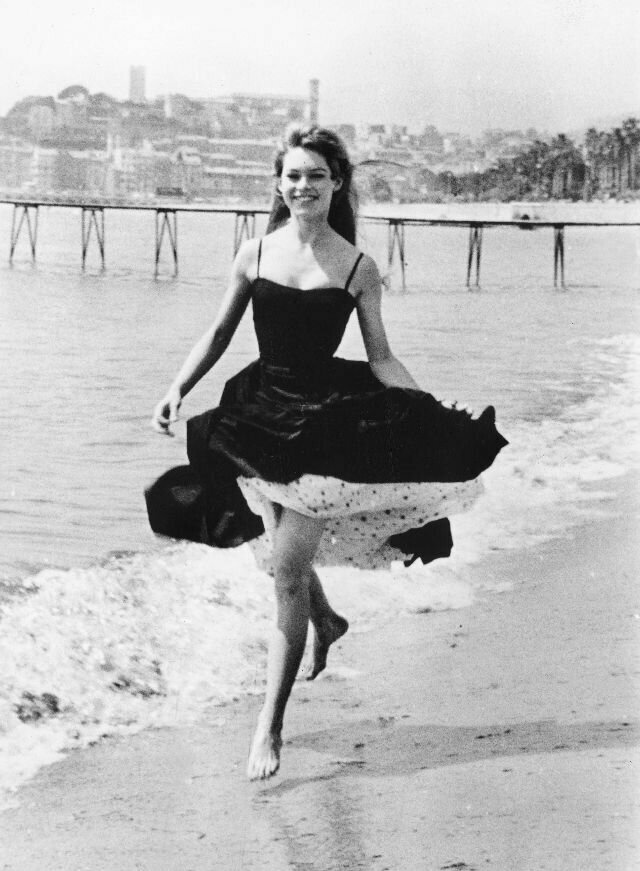 Брижит Бардо прогуливается по пляжу во время Каннского кинофестиваля, апрель 1956 года