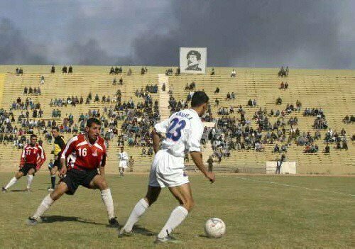 6. Футбольный матч в Ираке, на заднем плане дым от бомбардировок, 29 марта 2003 года