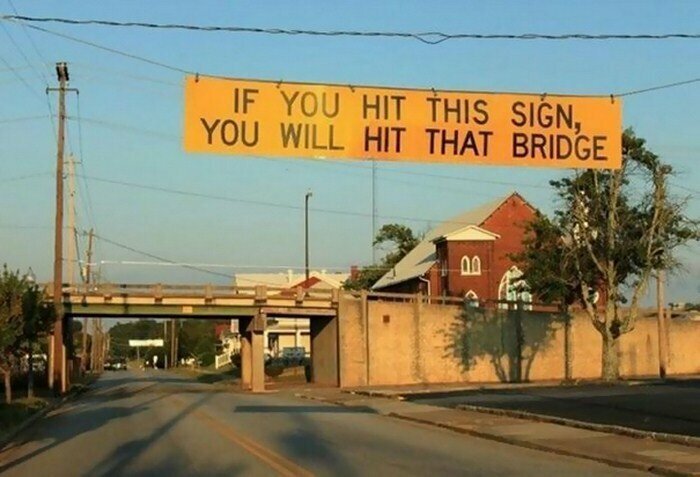 На знаке написано: «Если твоя машина задевает этот знак, то мост она тоже заденет»