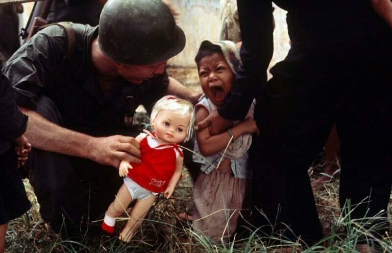 Американский морпех предлагает куклу ребёнку, Вьетнам, 1965 год.