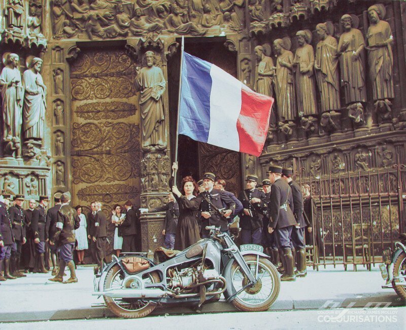 Французская мадемуазель стоит с французским триколором в знак уважения к освободителям. Собор Нотр-Дам в Париже, 26 августа 1944 г.