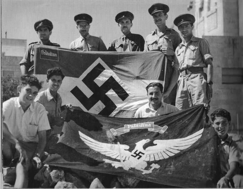 Английские полицейские и еврейские бойцы с флагами, найденными в «немецкой колонии» Иерусалима. Государство Израиль. 1948 год.