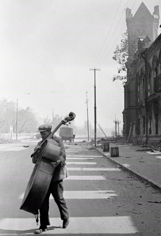 Музыкант симфонического оркестра уходит из разбитого театра, 1942 год, Сталинград. Фото: Эммануил Евзерихин.